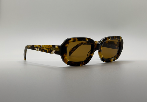 Sunglasses with tortoiseshell frame and dark lenses on a light gray background