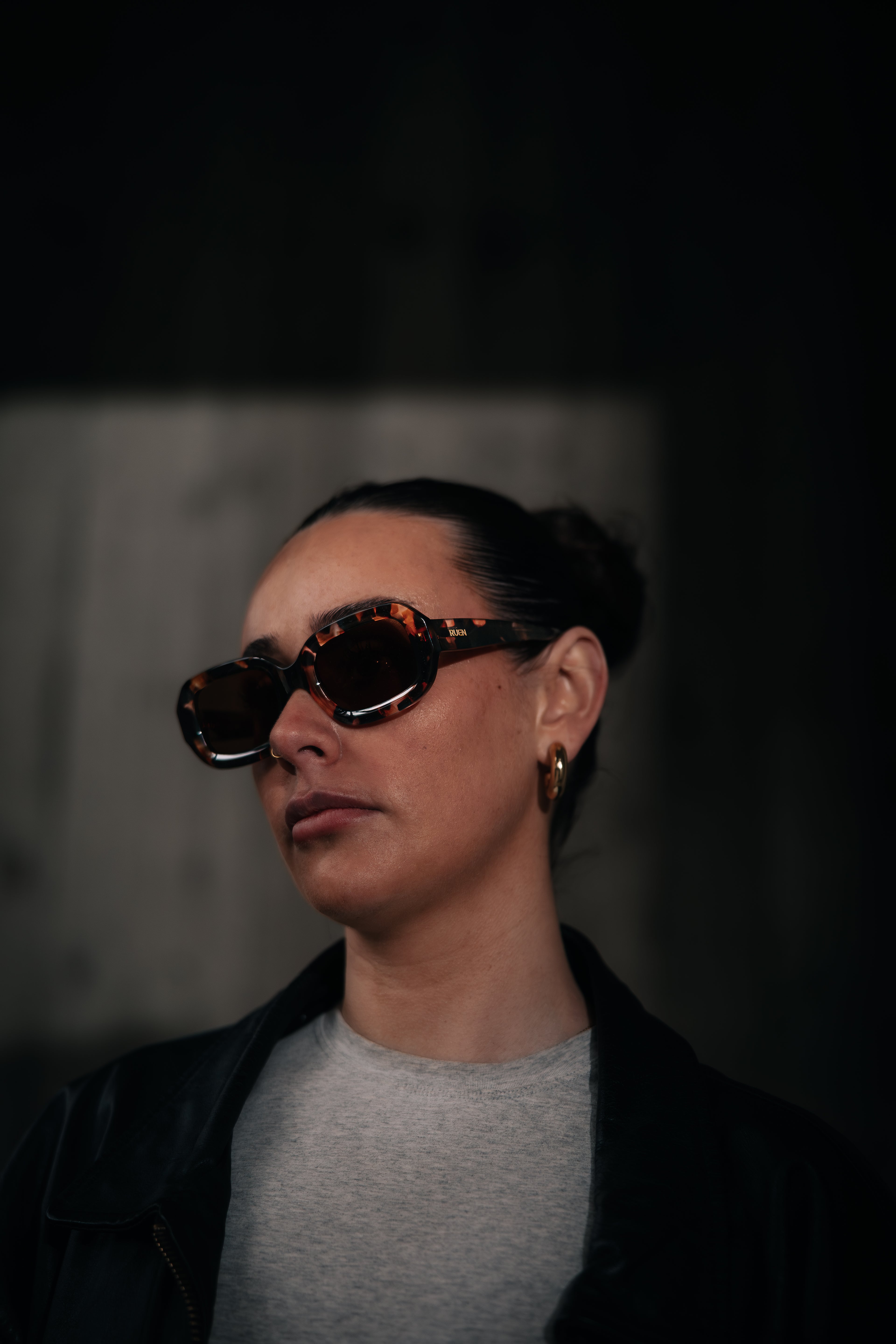 Person wearing sunglasses with a dark background