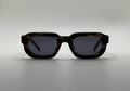 Sunglasses with a tortoiseshell frame on a light gray background