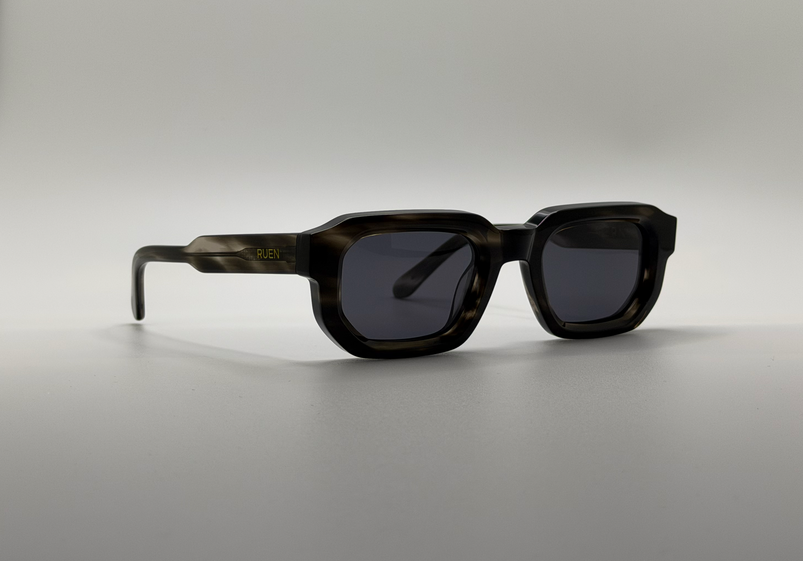 Sunglasses with dark lenses on a gray background