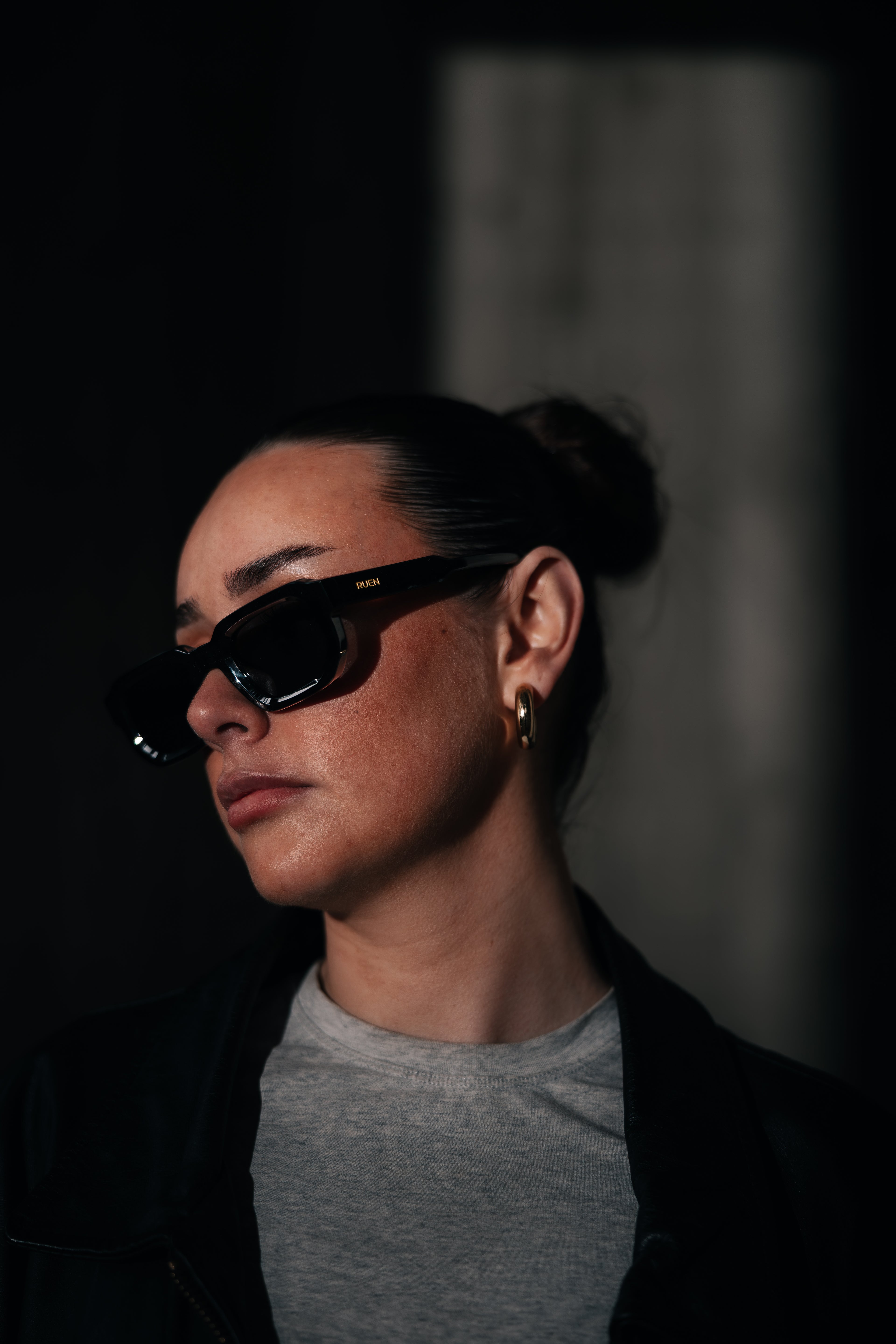 Person wearing sunglasses with a dark background