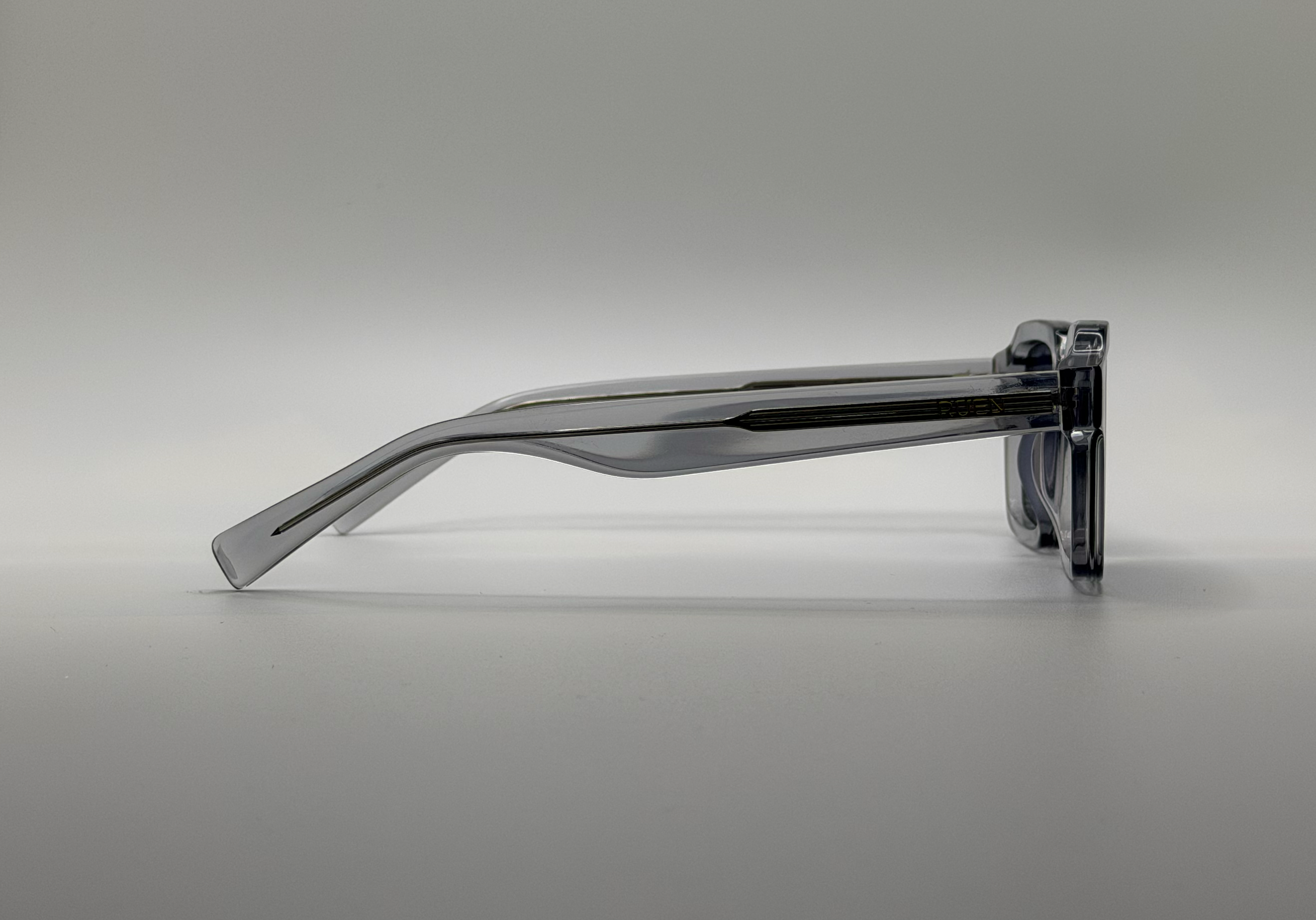clear sunglasses frame on a gray background