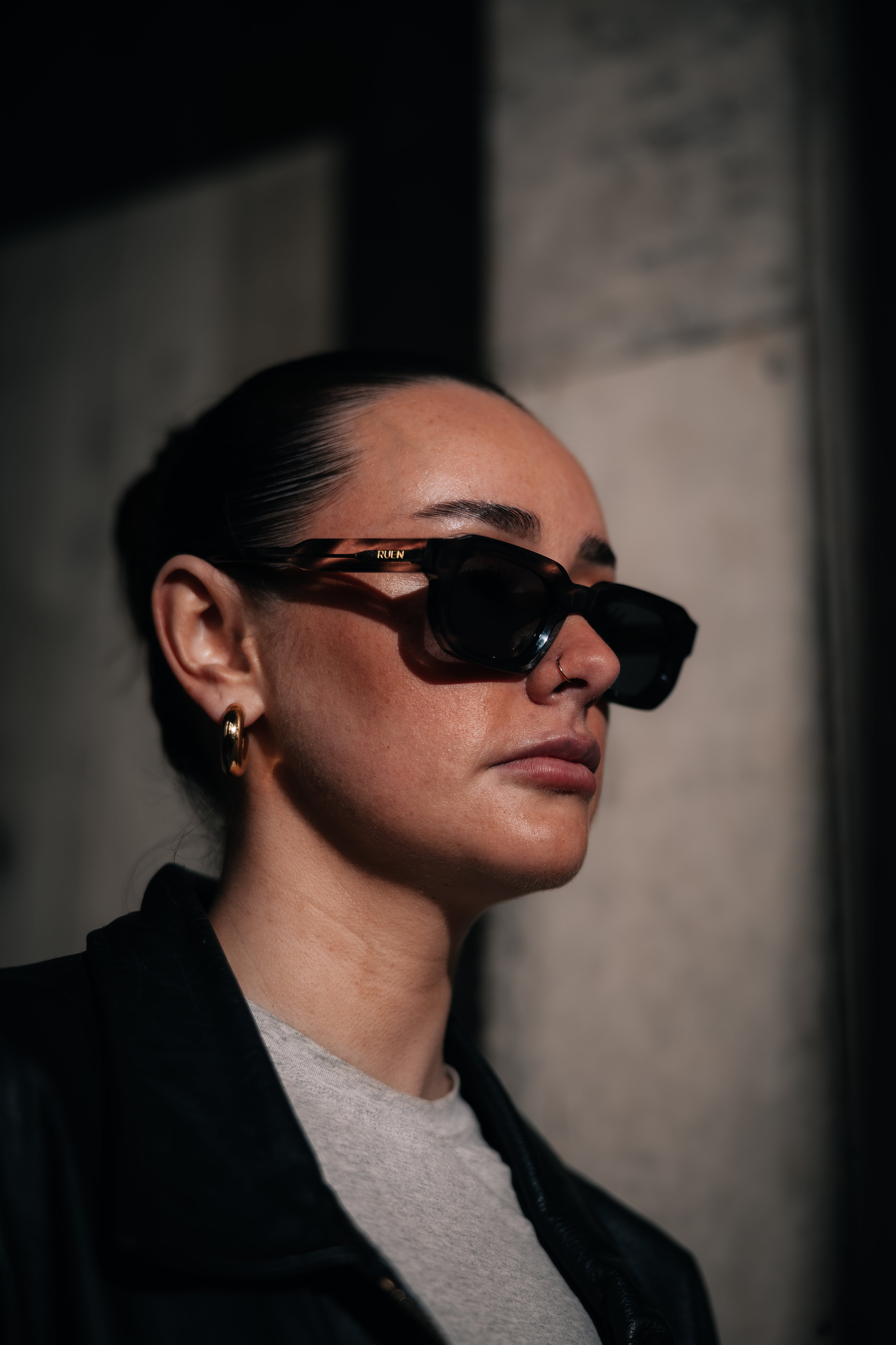 Person wearing dark sunglasses against a neutral background
