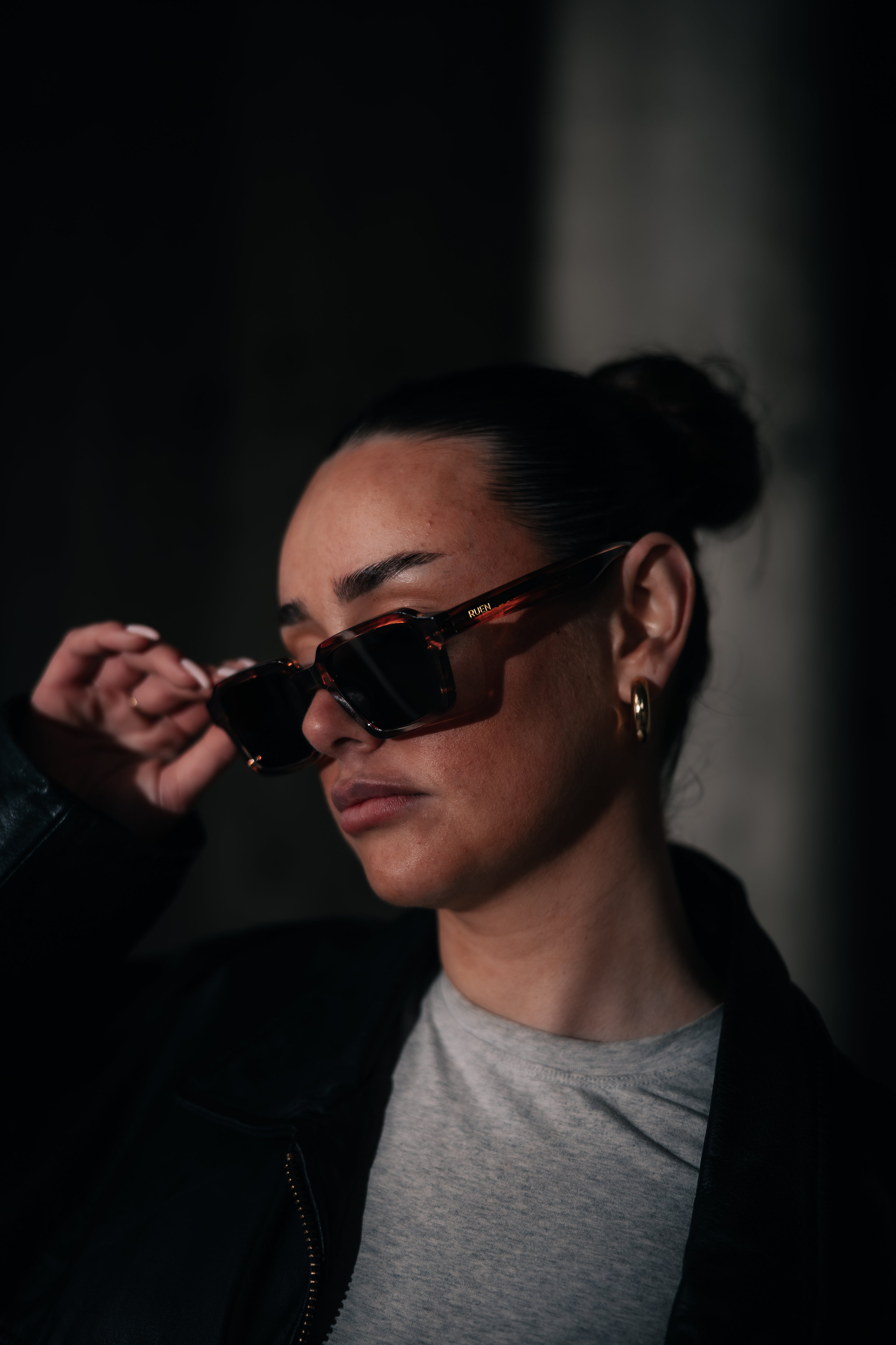 Person wearing sunglasses with a dark background