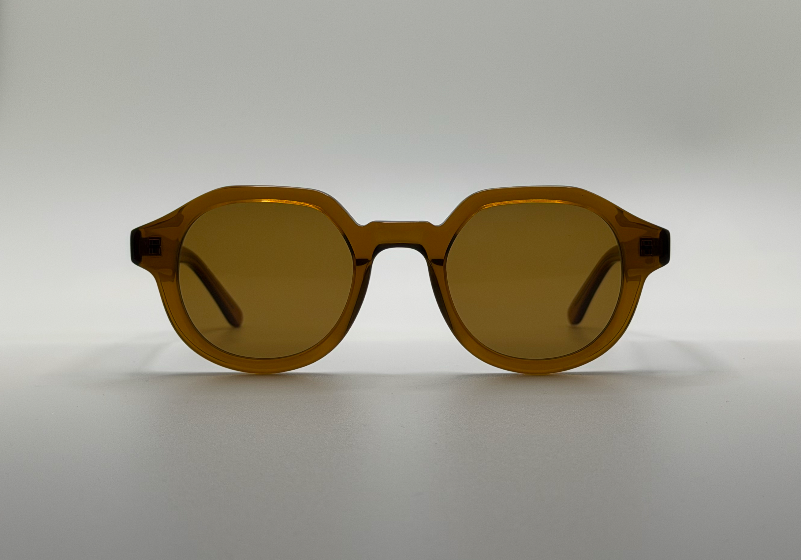 Brown sunglasses on a light gray background